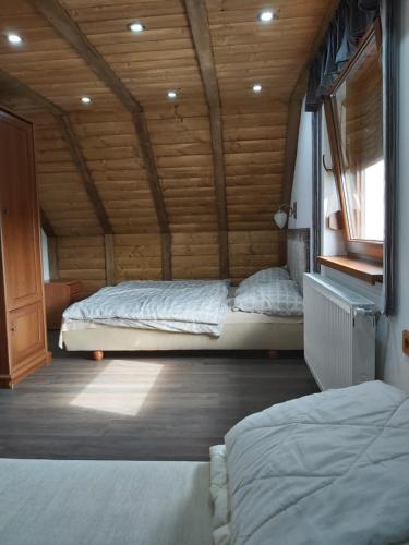 1 dormitorio con 2 camas en una cabaña de madera en Kovácsszénája Vendégház, en Kovácsszénája
