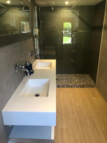 a bathroom with two sinks and a shower at Maison bord mer in Labenne