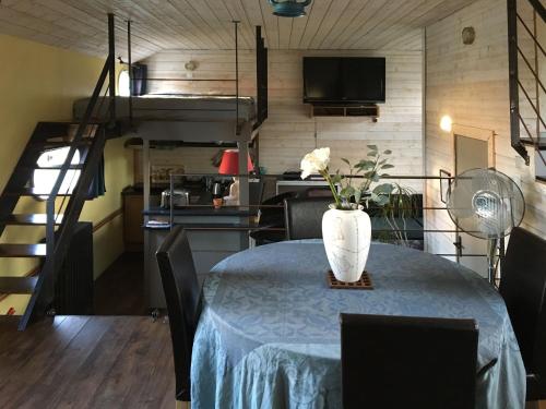 une pièce avec une table avec un vase de fleurs dessus dans l'établissement Boat For Guest, à Issy-les-Moulineaux