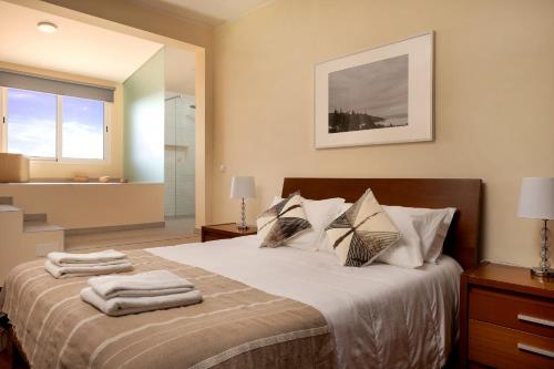 ein Schlafzimmer mit einem Bett mit Handtüchern darauf in der Unterkunft Funchal Bay View Villa by Homie in São Gonçalo