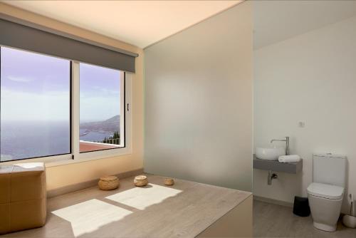 ein Badezimmer mit Toilette und großem Fenster in der Unterkunft Funchal Bay View Villa by Homie in São Gonçalo