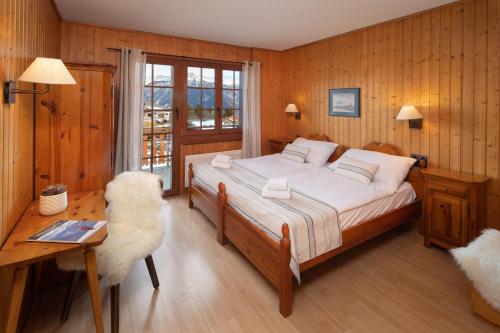 a bedroom with a bed and a table and a desk at Petit Paradis in Crans-Montana