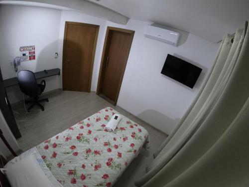 a hospital room with a bed and a desk at Hotel Zagonel in Chapecó