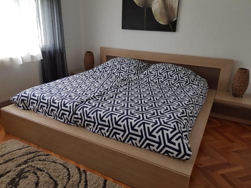 a bed with a black and white comforter on it at Matija in Gospić