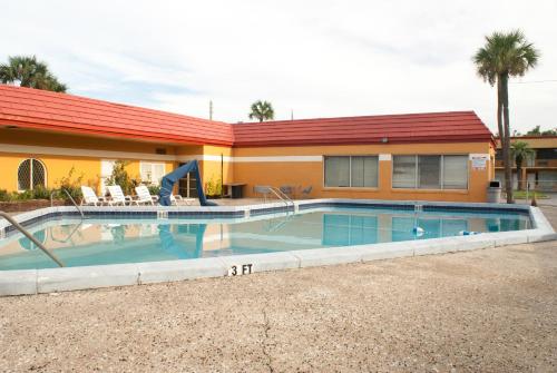 a swimming pool in front of a house at Scottish Inn Downtown Jacksonville in Jacksonville