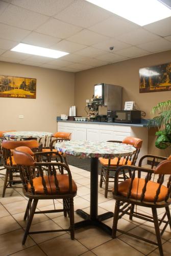 a dining room with two tables and chairs at Scottish Inn Downtown Jacksonville in Jacksonville