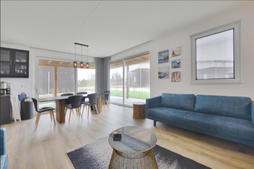uma sala de estar com um sofá azul e uma mesa em Casa Bos Schotsman Wellness em Kamperland