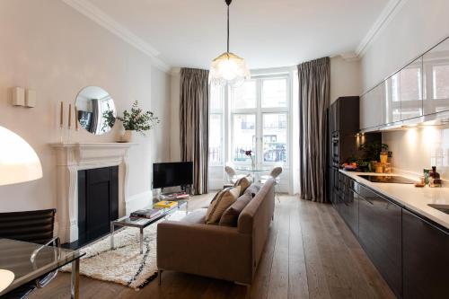 a living room with a couch and a fireplace at 56 Welbeck Street in London