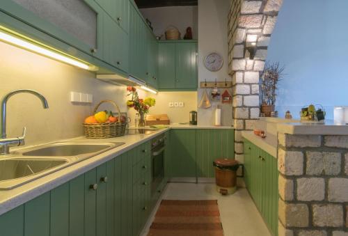 a kitchen with green cabinets and a sink at Komia Sea View Traditional in Komia