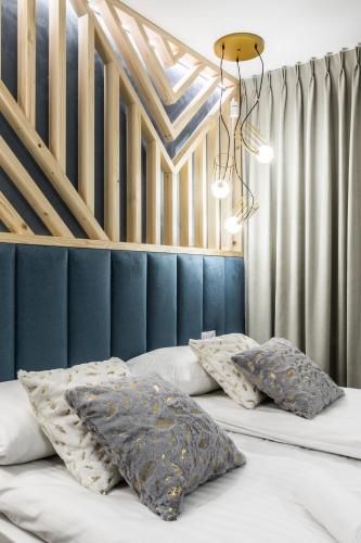 a bedroom with two beds with pillows and a ceiling at Aparthotel Prestige & SPA in Zakopane