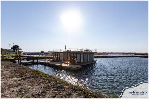 a small house on a dock in the water at Barcos Casa OstrAveiro in Aveiro