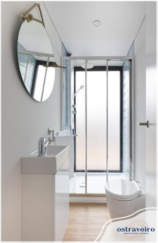 a white bathroom with a sink and a mirror at Barcos Casa OstrAveiro in Aveiro
