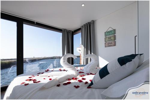 um quarto com cisnes feitos de rosas numa cama em Barcos Casa OstrAveiro em Aveiro