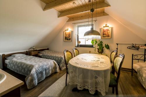 Zimmer mit 2 Betten und einem Tisch mit Stühlen in der Unterkunft Dworek Kaszubski in Gołubie