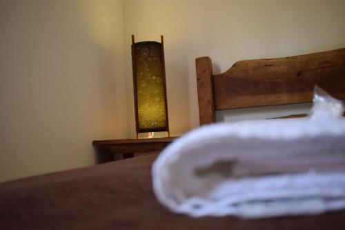 a close up of a bed with a lamp on a table at Pousada Colonetti in Lindóia