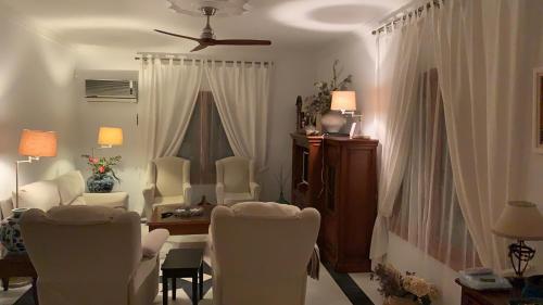 a living room with white chairs and a table at La Quinta - La Barrosa in Chiclana de la Frontera