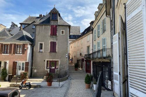 une allée dans une ville avec des bâtiments et un scooter dans l'établissement Aventurine, à Terrasson