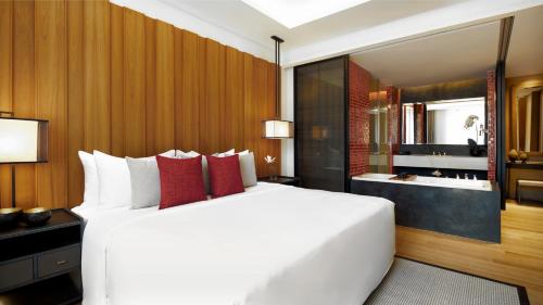 a bedroom with a large white bed and a bathroom at Anantara Chiang Mai Serviced Suites in Chiang Mai
