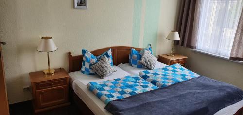 a bedroom with two beds with blue and white pillows at Landgasthof Graf Karstädt in Karstädt
