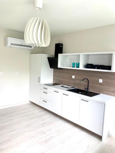a kitchen with white cabinets and a sink at APARTAMENTY POSEJDON in Świnoujście