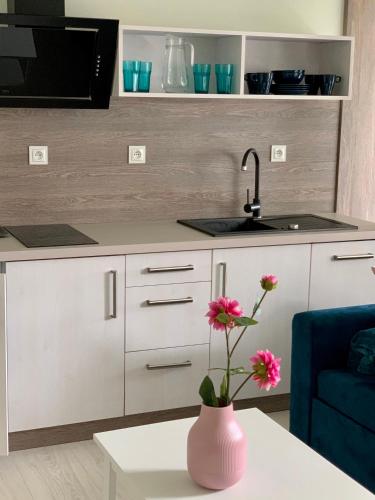 a kitchen with a vase with flowers on a table at APARTAMENTY POSEJDON in Świnoujście