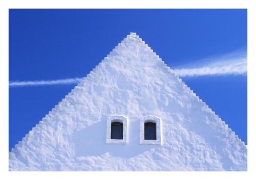 a white pyramid shaped building with a window in the snow at Casa.Peiso in Mörbisch am See