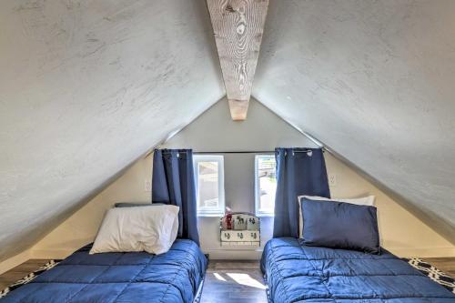 Cette chambre mansardée comprend 2 lits avec des oreillers bleus. dans l'établissement Kalispell Cabin 28 Miles to Glacier National Park!, à Kalispell