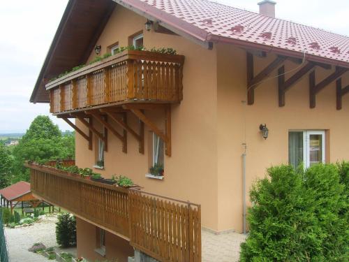 a house with wooden balconies on the side of it at Penzion Zlatá rybka in Podhájska