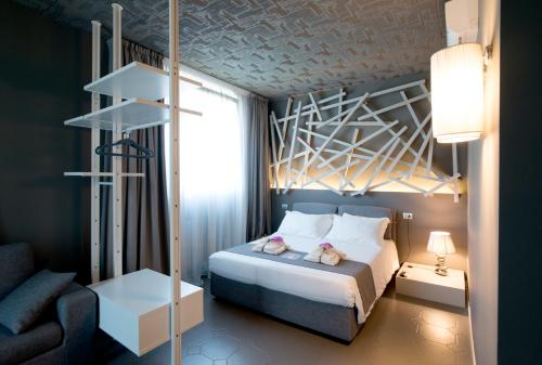 a small bedroom with a bed and a chair at Art B&B Design in Costa Volpino