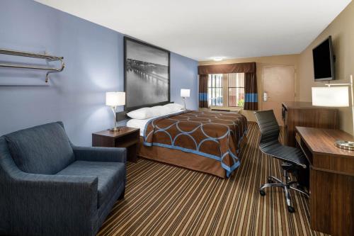 a hotel room with a bed and a desk at Super 8 by Wyndham Gadsden AL in Gadsden