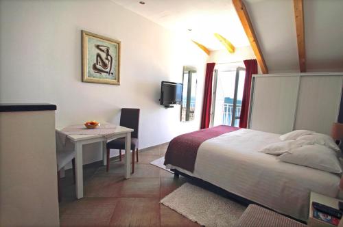 a bedroom with a bed and a desk and a table at Ante in Dubrovnik