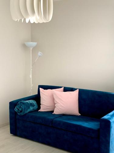 a blue couch with three pillows on it at APARTAMENTY POSEJDON in Świnoujście