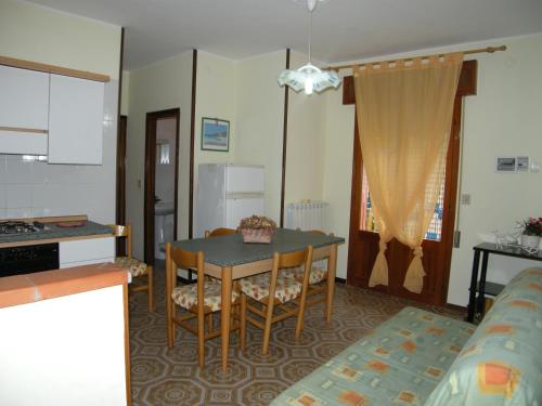 eine Küche und ein Esszimmer mit einem Tisch und Stühlen in der Unterkunft Villa Milviana appartamento in Rosolina Mare