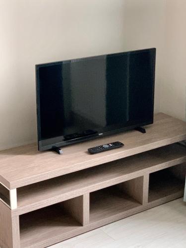 a flat screen tv sitting on a wooden entertainment center at APARTAMENTY POSEJDON in Świnoujście