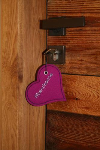 a purple heart shaped tag hanging on a door at Gasthaus Am Ödenturm in Chammünster