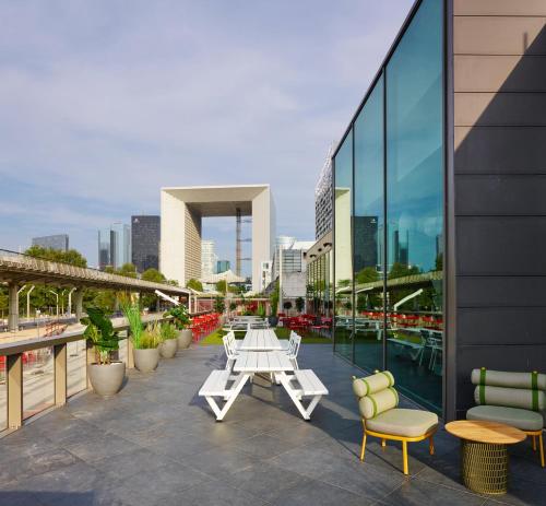 un patio avec des tables et des chaises dans un bâtiment dans l'établissement citizenM Paris La Défense, à Nanterre