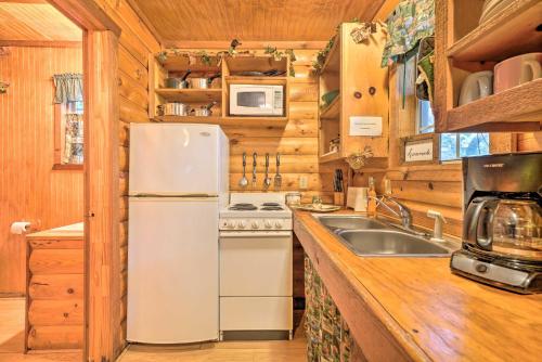 a kitchen with a white refrigerator and a sink at Cedar Falls Cabin Nestled by Honey Creek in Davis