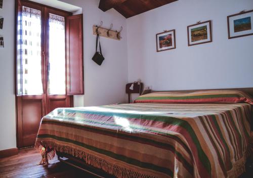 a bedroom with a bed with a blanket on it at Villa Schinoppi in Amandola