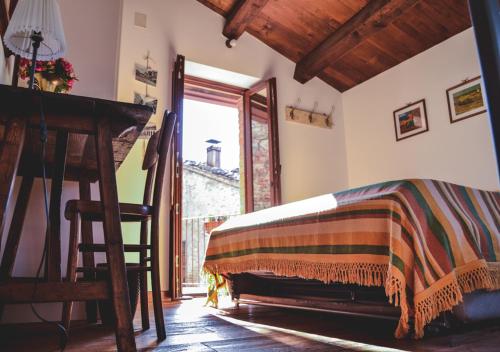 a bedroom with a bed and a desk and a window at Villa Schinoppi in Amandola