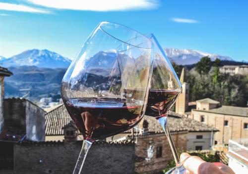 a person holding a glass of red wine at Villa Schinoppi in Amandola