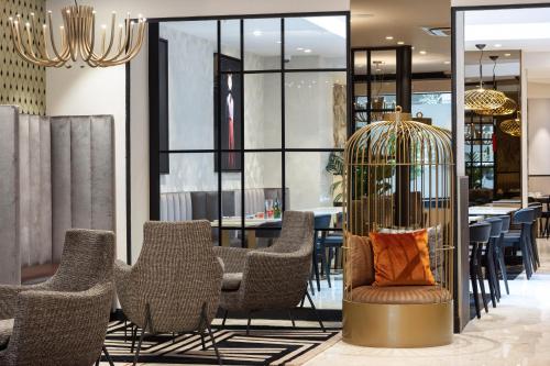 a room with chairs and a birdcage at Best Western Plus Hôtel Massena Nice in Nice