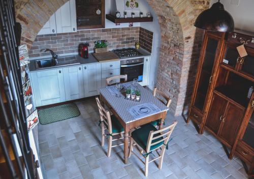 a kitchen with a table with chairs and a stove at Villa Schinoppi in Amandola