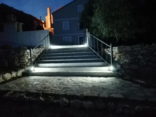 un conjunto de escaleras con luces por la noche en Country House, en Čunski