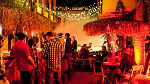 a group of people in a restaurant with people standing around at Banana Bungalow West Hollywood Hotel & Hostel in Los Angeles