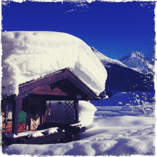a pile of snow on top of a cabin at Gästehaus Fritz in Mittelberg