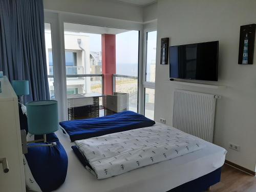 a bedroom with a bed and a tv and a window at Residenz Bollwark Port Olpenitz in Kappeln