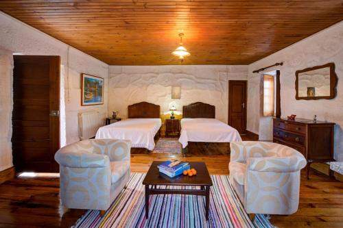 um quarto de hotel com duas camas e duas cadeiras em Casa do Castelo em Arnóia em Celorico de Basto