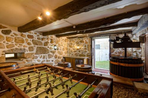 um quarto com uma mesa de bilhar e uma parede de pedra em Casa do Castelo em Arnóia em Celorico de Basto