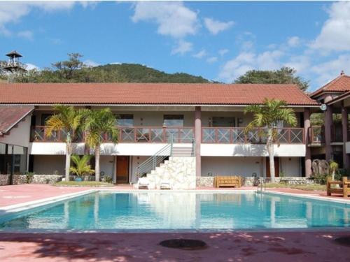 un complexe avec une piscine en face d'un bâtiment dans l'établissement Amami Resort Bashayamamura / Vacation STAY 81475, à Amami