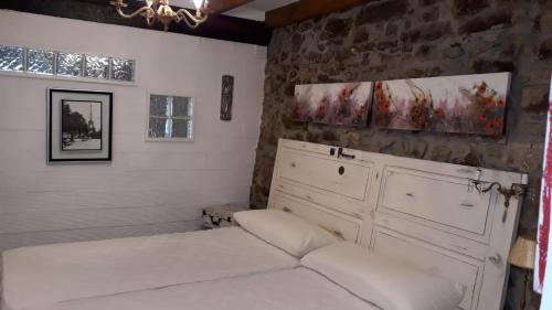 RuiseñadaにあるCASA TINAの石壁のベッドルーム1室(ベッド2台付)